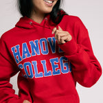 Person wearing a red 'Hanover College' hoodie against a plain background