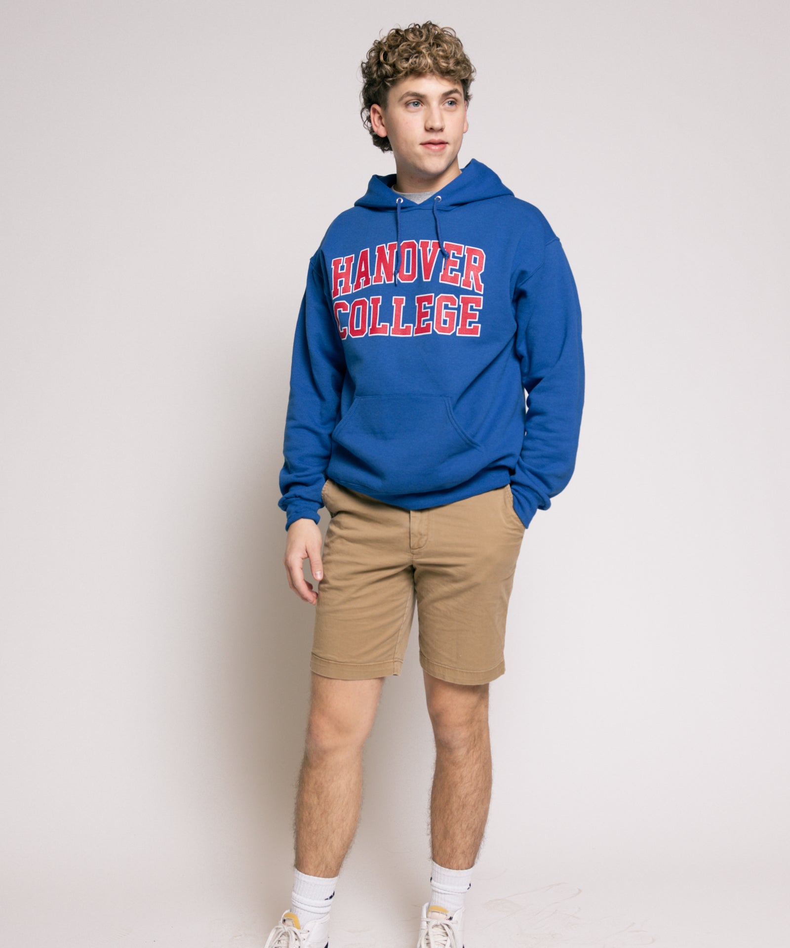 Person wearing a blue 'Hanover College' hoodie on a plain background